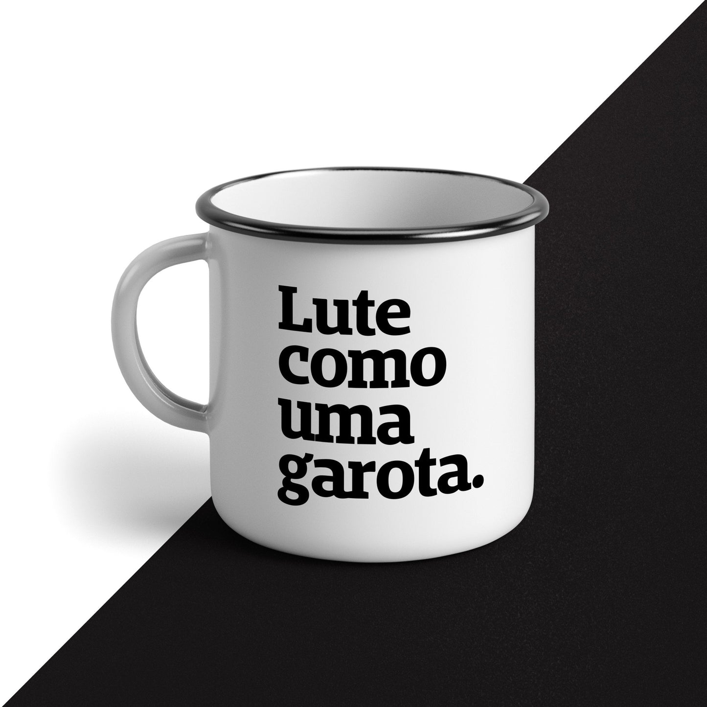 Foto preta e branca de uma caneca esmaltada branca com a frase lute como uma garota em preto.