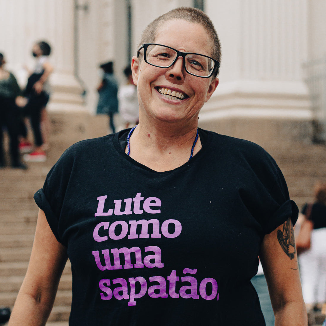 card branco escrito PRÉ-VENDA e imagem do mockup de uma camiseta preta com a frase lute como uma sapatão em roxo. 